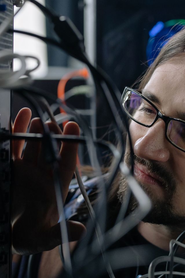 Tehnician lucrând la infrastructură de găzduire web și cabluri de rețea.